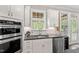 Bright kitchen featuring stainless steel appliances, sleek countertops and white cabinetry and sink at 113 Old Ballentine Way, Holly Springs, NC 27540