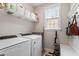 Functional laundry room with washer, dryer, storage shelves and a convenient folding area at 113 Old Ballentine Way, Holly Springs, NC 27540