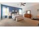 Spacious main bedroom featuring blue accent wall, ceiling fan, and natural light at 113 Old Ballentine Way, Holly Springs, NC 27540