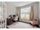 Bright home office featuring a large window, neutral decor, and a comfortable seating area at 113 Old Ballentine Way, Holly Springs, NC 27540