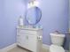 Clean bathroom with a single vanity, a round mirror, and light purple walls at 1180 Duke Farm Dr, Wake Forest, NC 27587