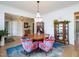 Chic dining room features hardwood floors, a chandelier, and unique floral armchairs around a round table at 1180 Duke Farm Dr, Wake Forest, NC 27587