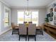 Elegant dining room with a wooden table, upholstered chairs, and large windows with ample natural light at 1180 Duke Farm Dr, Wake Forest, NC 27587