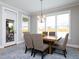 Light-filled dining room with a wooden table, upholstered chairs, and a doorway to a stone patio at 1180 Duke Farm Dr, Wake Forest, NC 27587