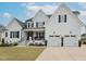 Beautiful white brick home with a covered porch and two-car garage, offering curb appeal at 1180 Duke Farm Dr, Wake Forest, NC 27587