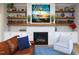 Cozy living room features a stone fireplace, built-in shelves, and hardwood floors for a warm ambiance at 1180 Duke Farm Dr, Wake Forest, NC 27587