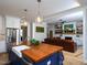 Open concept kitchen with a wood island, stainless sink, and view to living room with fireplace and leather sofa at 1180 Duke Farm Dr, Wake Forest, NC 27587