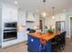 Stylish kitchen with white cabinets, a stainless-steel oven, and a blue island with wood countertop and seating at 1180 Duke Farm Dr, Wake Forest, NC 27587