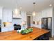 Bright kitchen with white cabinets, stainless appliances, and a large wooden island with pendant lighting at 1180 Duke Farm Dr, Wake Forest, NC 27587