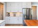 Kitchen featuring white cabinets, stainless steel refrigerator, and quartz countertops, offering a sleek modern design at 1180 Duke Farm Dr, Wake Forest, NC 27587