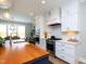 Bright kitchen featuring stainless steel appliances, white cabinets, hardwood floors, and a wood-topped island at 1180 Duke Farm Dr, Wake Forest, NC 27587
