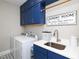 Bright laundry room with blue cabinets, white countertop, and modern washer/dryer at 1180 Duke Farm Dr, Wake Forest, NC 27587