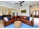 Spacious living room with a leather couch, modern ceiling fan, and an open layout connecting to the kitchen at 1180 Duke Farm Dr, Wake Forest, NC 27587