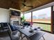 Inviting screened porch with a stone fireplace, ceiling fan, and outdoor dining area at 1180 Duke Farm Dr, Wake Forest, NC 27587