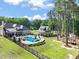 Aerial view of a home, pool, outbuilding and playhouse on a large, grassy and treed lot at 120 Lu Tom Ln, Wendell, NC 27591