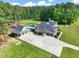 Aerial view of a brick home with a pool, detached garage, and a long driveway on a large lot at 120 Lu Tom Ln, Wendell, NC 27591