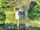 Aerial view of a brick home with a pool, detached garage, and a long driveway on a large treed lot at 120 Lu Tom Ln, Wendell, NC 27591