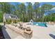 Wide view of the large backyard pool, patio seating, fire pit, and pool house at 120 Lu Tom Ln, Wendell, NC 27591