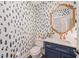 Chic powder room boasts navy blue vanity, gold fixtures, and unique patterned wallpaper for a stylish design at 120 Lu Tom Ln, Wendell, NC 27591
