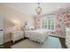 Charming bedroom featuring a floral accent wall, shuttered windows, and designer lighting at 120 Lu Tom Ln, Wendell, NC 27591
