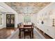 Dining room with hardwood floors, stylish ceiling wallpaper, chandelier, and white wainscoting at 120 Lu Tom Ln, Wendell, NC 27591