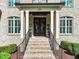 Inviting home entrance with brick steps, black iron railings and wreaths adorning double front doors at 120 Lu Tom Ln, Wendell, NC 27591