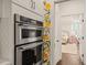 Modern kitchen featuring stainless steel double ovens with view to the adjacent bedroom at 120 Lu Tom Ln, Wendell, NC 27591
