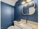 Stylish powder room with blue walls, decorative mirror, and granite countertop with a white sink at 120 Lu Tom Ln, Wendell, NC 27591