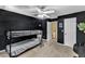Modern bedroom featuring sleek black walls, ceiling fan, and doorway to hall at 1201 Red Beech Ct, Raleigh, NC 27614