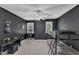 Modern bedroom featuring sleek black walls, ceiling fan, and two bright windows at 1201 Red Beech Ct, Raleigh, NC 27614