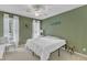 The cozy bedroom has green walls, white trim, a ceiling fan, and lots of light from the windows at 1201 Red Beech Ct, Raleigh, NC 27614