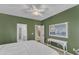 Green bedroom features a ceiling fan, neutral carpet, and a view to an adjoining bathroom and hallway at 1201 Red Beech Ct, Raleigh, NC 27614