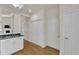 View of kitchen cabinets, granite countertops, hardwood flooring, and hallway with access to additional rooms at 1201 Red Beech Ct, Raleigh, NC 27614