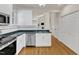 This kitchen features a stainless steel dishwasher, granite countertops, white cabinets, and hardwood floors at 1201 Red Beech Ct, Raleigh, NC 27614