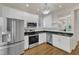 Bright kitchen with white cabinetry, stainless steel appliances, granite countertops, and a view to the next room at 1201 Red Beech Ct, Raleigh, NC 27614