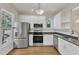 Modern kitchen design showcases stainless steel appliances, granite counters, white cabinets, and hardwood flooring at 1201 Red Beech Ct, Raleigh, NC 27614