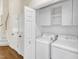 Laundry area includes a washer, dryer, shelving, and cabinetry, providing efficient space for laundry tasks at 1201 Red Beech Ct, Raleigh, NC 27614