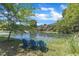 Lake view showcasing three blue Adirondack chairs, fountain, and mature landscaping at 1201 Red Beech Ct, Raleigh, NC 27614