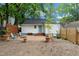 Charming backyard with a fire pit, Adirondack chairs, and a newly planted tree near the back door at 1209 Eva St, Durham, NC 27703