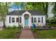 Charming home with a blue front door, brick walkway, and a cozy front porch seating area at 1209 Eva St, Durham, NC 27703