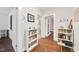 Hallway with hardwood floors and built-in shelving leading to the kitchen and other rooms at 1209 Eva St, Durham, NC 27703