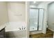 Bright bathroom with a soaking tub and glass-enclosed shower with wood-look flooring at 121 Earnest Way, Kenly, NC 27542