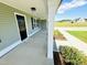Close-up of a front porch featuring classic columns, flower beds, and a black front door at 121 Earnest Way, Kenly, NC 27542