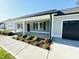 Eye-level shot of a home's front porch with flower beds, columns, and a dark front door at 121 Earnest Way, Kenly, NC 27542