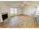 Well-lit living room featuring wood floors, a fireplace, and seamless integration to the kitchen at 121 Earnest Way, Kenly, NC 27542