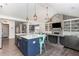 Open-concept kitchen flowing into the living area with a large island and modern pendant lighting at 123 Jonalker Ct, Clayton, NC 27520