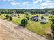 Stunning aerial shot of an estate with green lawns, complemented by a fence and mature trees under a blue sky at 130 Skipwith Dr, Wendell, NC 27591