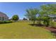 Expansive backyard featuring a lush green lawn with mature trees, and a fence for added privacy at 130 Skipwith Dr, Wendell, NC 27591