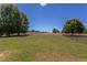 Vast backyard featuring a lush green lawn with mature trees, and a fence, offering a private and serene outdoor space at 130 Skipwith Dr, Wendell, NC 27591
