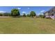 Expansive backyard featuring a well-manicured lawn, mature trees, and play set, perfect for outdoor activities at 130 Skipwith Dr, Wendell, NC 27591